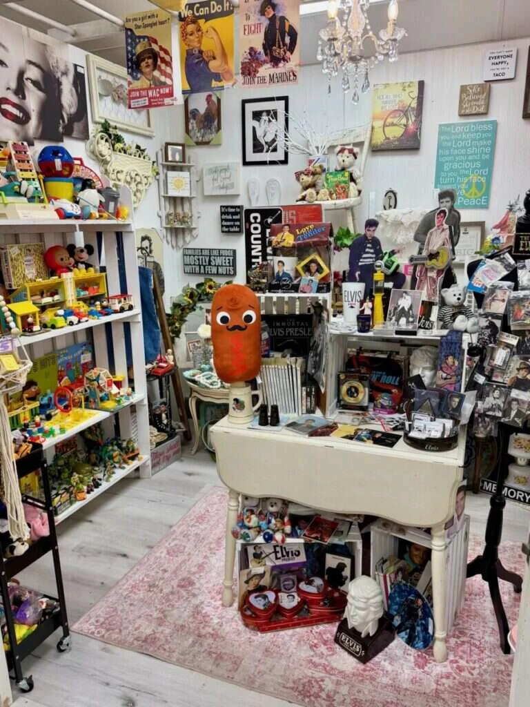 Divine Finds booth at Twisted Sisters Vintage Market, featuring vintage toys, Elvis memorabilia and retro posters