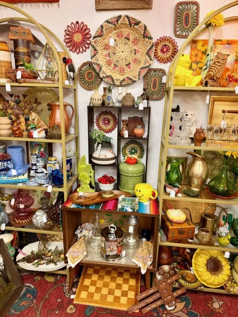 Live Simply Vintage booth at Twisted Sisters Vintage Market, with arched shelves of retro pottery, glassware and woven wall baskets